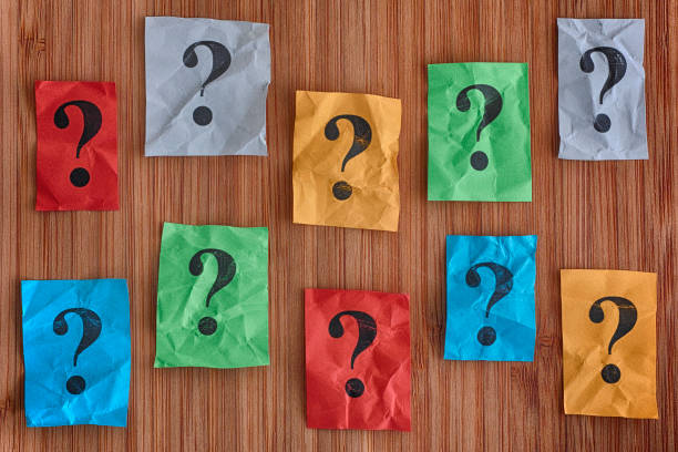 istock Colorful paper notes with question marks on a wooden background 697234750