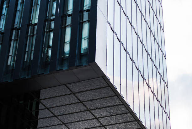 istock Underside panoramic and perspective view to steel blue glass high rise building. Modern skyscrapers in business district in light at sunset. 697235044