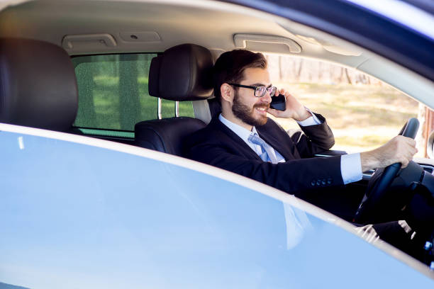istock Businessman talking on a cell phone in a car 697236326