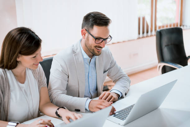 istock Two entrepreneurs sitting together working in an office desk with laptop 697236450