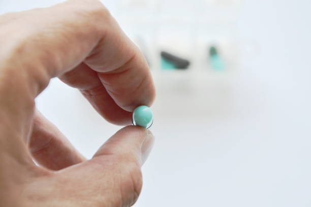 istock medicine capsule picking in finger with drug box 697239026