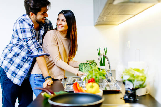istock Young couple have fun in modern kitchen indoor while preparing vegetables food for lunch 697249134