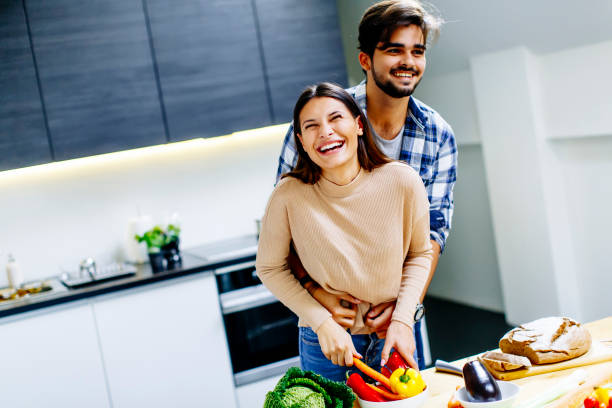 istock Young couple have fun in modern kitchen indoor while preparing vegetables food for lunch 697249140