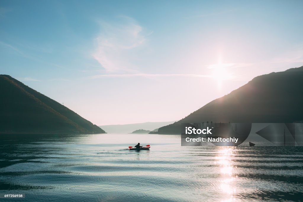 Kayaks in the lake. Tourists kayaking on the Bay of Kotor, near Kayaks in the lake. Tourists kayaking on the Bay of Kotor, near the town of Perast in Montenegro. Aerial Photo drone. Canoeing Stock Photo