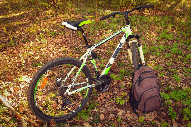 istock A bicycle and a backpack in a green park outdoors 697257126