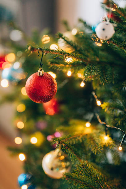 istock A small Christmas tree in a pot, decorated with balls, garlands 697260154