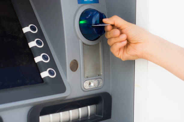 istock Hand inserting ATM credit card into bank machine 697263658