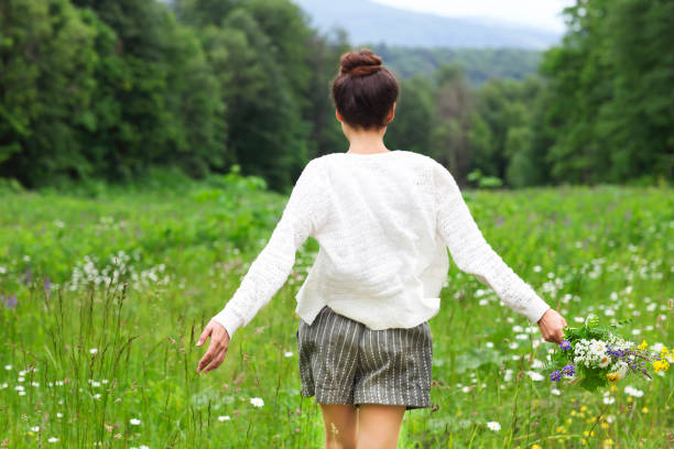 istock Happy pretty brunette woman in chamomile field 697267612