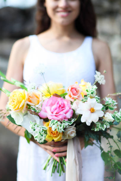 istock Young bride in white wedding dress holding beautiful bouquet 697267654