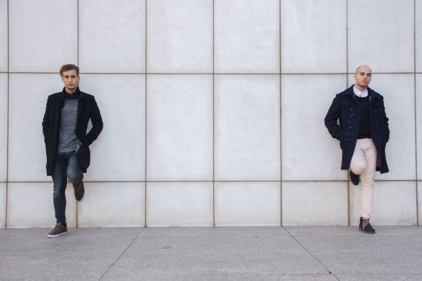 istock Two young entrepreneurs leaning against a white wall. 697273982
