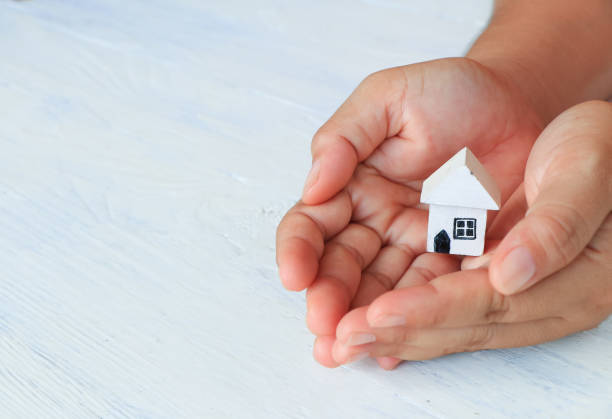 istock Woman hands holding house model 697277988