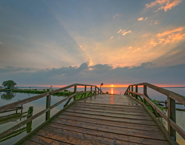 istock Sunset over bridge at lake with majestic cloudscape 697302682