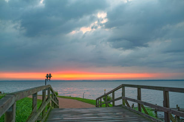 istock Sunset over bridge at lake with majestic cloudscape 697305022