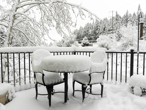 A snow covered deck and furniture. “CreativeContentBrief” 700063863 Monochrome.