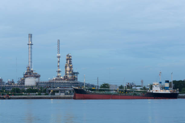 istock Tank boat on river over oil refinery 697305434