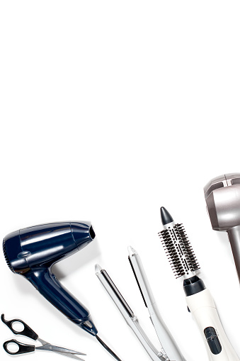 Various hair styling tools on white background, top view, copy space