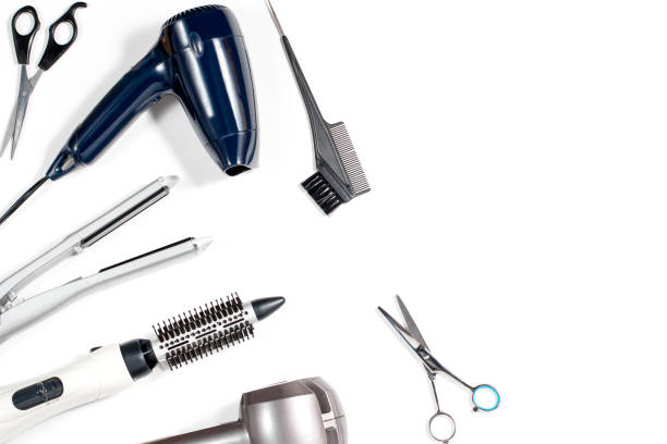 Various hair styling devices on white background, top view