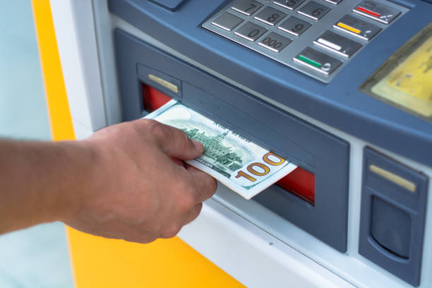 istock taking money out of the ATM 697309120