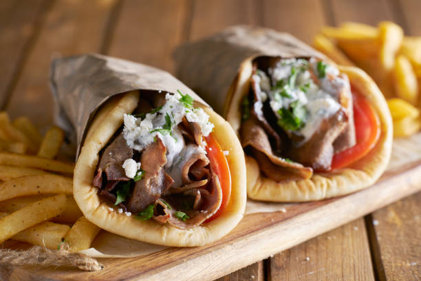 two greek gyros with shaved lamb and french fries two greek gyros with shaved lamb and french fries shot with selective focus greek food stock pictures, royalty-free photos & images