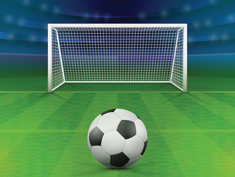 Soccer ball on green field in front of goal post