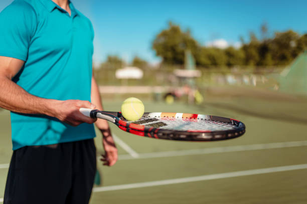 istock Male tennis player hand with racket and ball 697330536