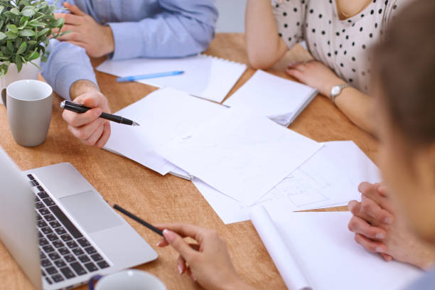 istock Hands of business people meeting around table 697343012