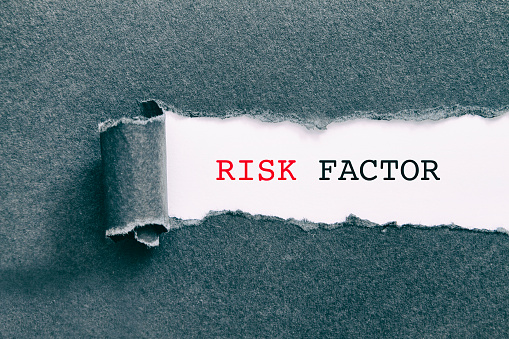 RISK FACTOR written under torn paper.