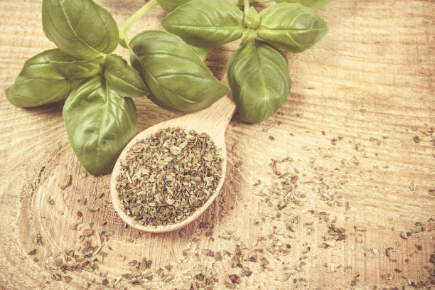 istock Raw green basil and dried, on the wooden table. 697345152