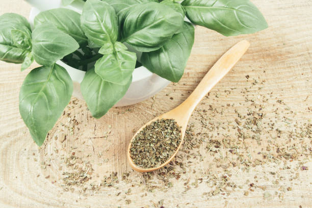 istock Raw green basil and dried, on the wooden table. 697347968