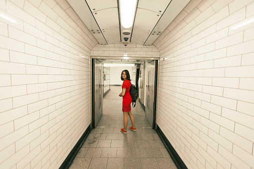 Woman in red dress ina subway station