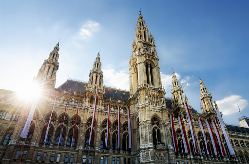The Wiener Rathaus (Vienna City Hall, Austria) at sunset, with austrian flags over the facade
