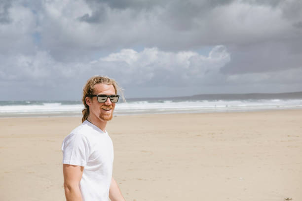 istock Candid Summer Portrait, Man walking along Towan Beach, Newquay 697354762