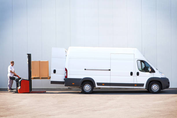 Courier is loading the van with parcels. Courier loading the parcels with forklift. commercial land vehicle stock pictures, royalty-free photos & images