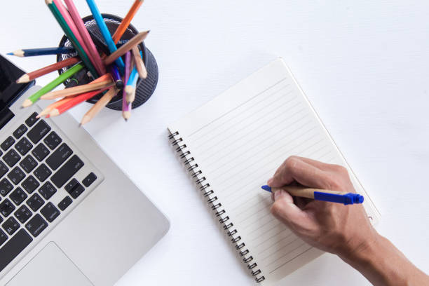 istock white office desk table with laptop,Blank notebook page for input the text in the middle,Top view 697364734