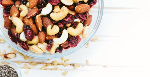 istock Mixed nuts in a bowl on a wooden background 697365026