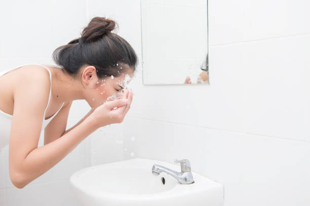 istock woman washing face 697365498