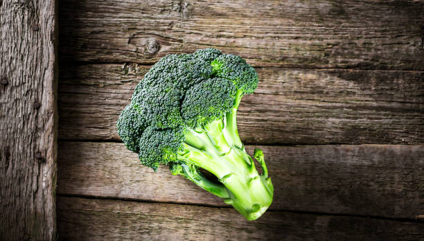 istock Fresh broccoli on a dark wooden background, top view 697366192