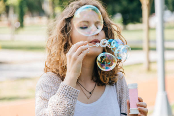 istock Young woman blowing bubbles outdoor 697371824