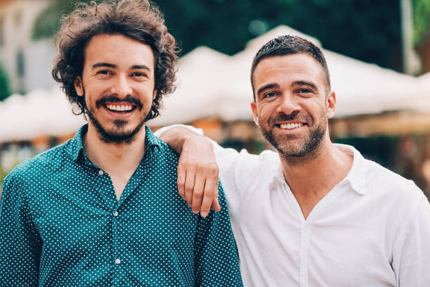 istock Two cheerful men outdoors on the street 697375680