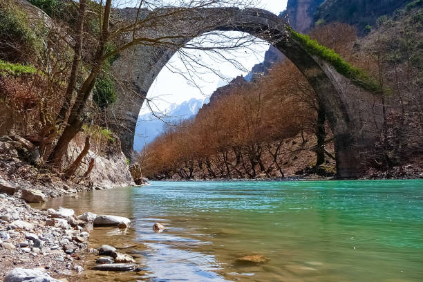 istock Old stone arch bridge over Aoos river, in Konitsa, Greece 697379860