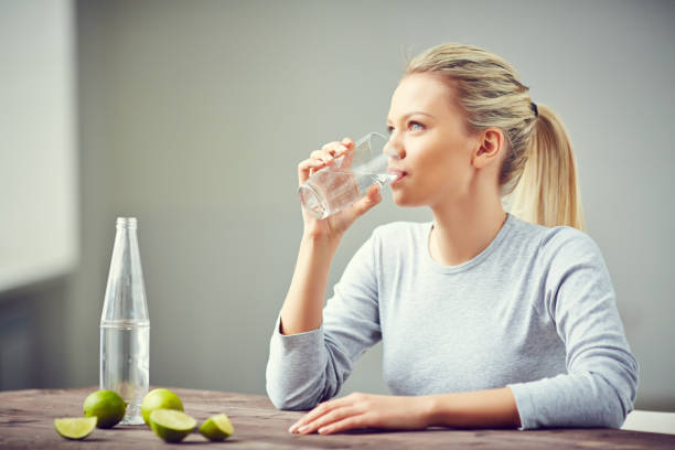 boire plus d’eau - water women glass healthy eating photos et images de collection