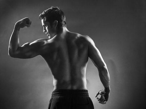 Latin Fighter Posing On A Black Background with smoke in the air.