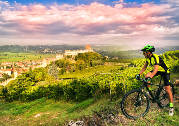 Cyclist admires the Soave castle views. Cyclist admires from the hill the Soave castle views. Hever Castle stock pictures, royalty-free photos & images