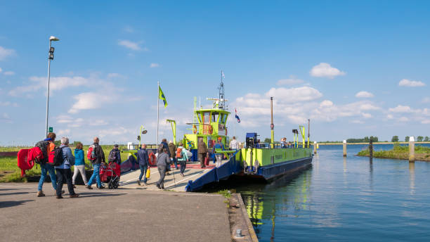 People and ferry leaving Tiengemeten island in Haringvliet estuary, Netherlands Passengers entering ferry boat leaving Tiengemeten island in Haringvliet estuary, South Holland, Netherlands tiengemeten stock pictures, royalty-free photos & images