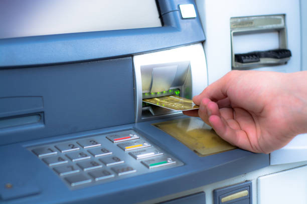 insertar tarjeta atm mano - insertar fotografías e imágenes de stock