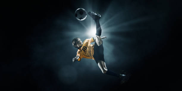 istock Soccer kids player kicking ball in spotlight 697427156