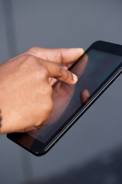 istock african american hand holding digital touch screen tablet 697427300