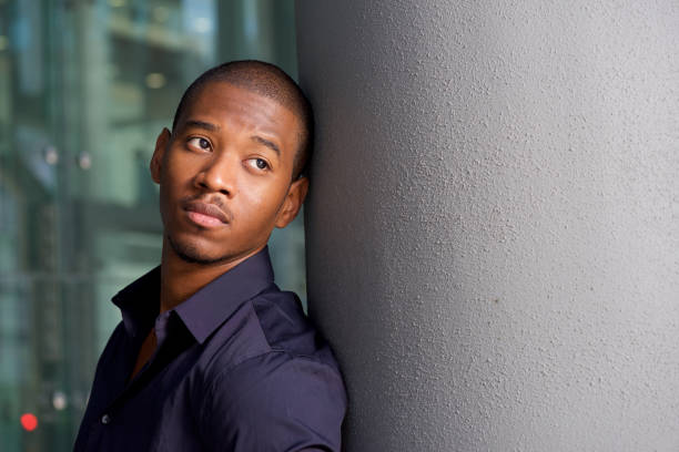 istock cool young black guy leaning on wall glancing away 697427404