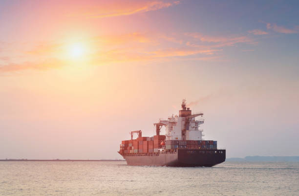 istock Container Cargo freight ship with working crane bridge in shipyard at dusk for Logistic Import Export background 697445144