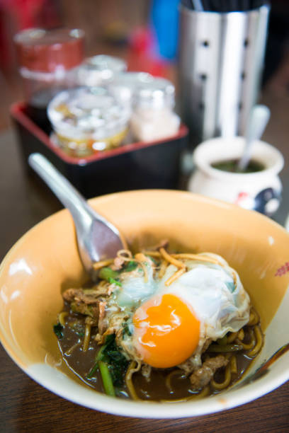 istock yellow noodle with pork and eggs 697451510